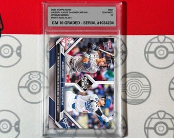 May include: A baseball card featuring Aaron Judge and Shohei Ohtani from the 2024 Topps Now World Series collection. The card is graded Gem Mint 10 and has a serial number of #1034234.