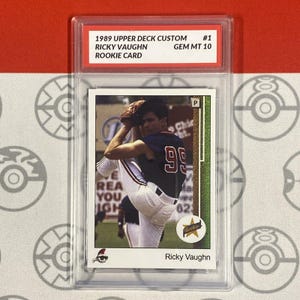 Puede incluir: Una tarjeta de béisbol de novato de Ricky Vaughn de 1989 Upper Deck Custom, calificada GEM MT 10, en un estuche protector. La tarjeta muestra a Ricky Vaughn lanzando, con un uniforme azul y rojo con el número 99.