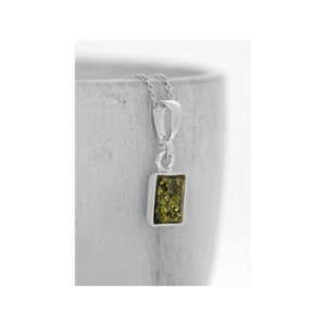 Puede incluir: Un collar de cadena de plata con un colgante cuadrado con una piedra de ámbar verde.