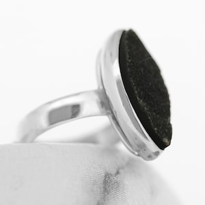 以下が含まれることがあります： ベゼルセッティングにセットされた黒い楕円形の石が付いたシルバーリング