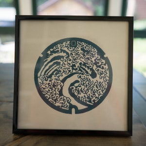 Woodblock Print of Hokusai Great Wave manhole cover in Obuse, Japan