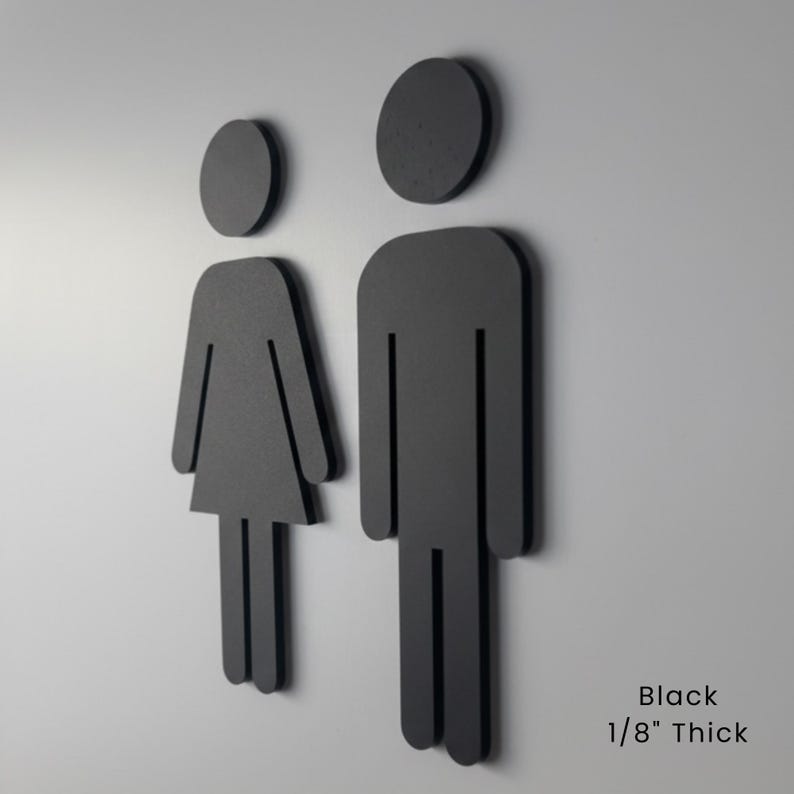 K&ouml;nnte beinhalten: Zwei schwarze Toilettenschilder mit stilisierten menschlichen Figuren, eine mit einer Kleiderform und eine mit einer rechteckigen Rumpfform. Die Schilder sind schwarz und 0,32 cm dick, wie durch den Text Black 1/8 inch Thick angegeben.