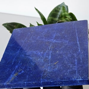 Könnte beinhalten: Ein quadratischer, polierter Lapislazuli-Untersetzer in tiefem Blau mit weißen Adern. Der Untersetzer ist aus Naturstein gefertigt und hat eine glatte, polierte Oberfläche.