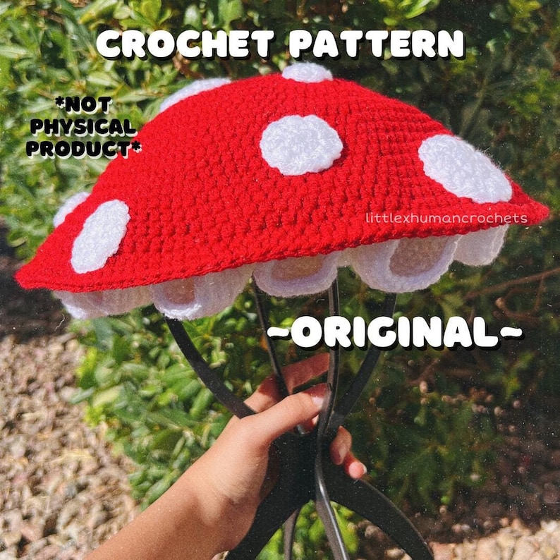 May include: Crochet pattern for a red and white mushroom hat. The pattern is labelled "*NOT PHYSICAL PRODUCT*" and "ORIGINAL".