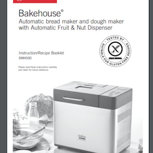 Op de afbeelding: Een zilveren en grijze Sunbeam Bakehouse broodbakmachine met een digitaal display en een fruit- en noten dispenser. De broodbakmachine staat op een wit aanrecht met een glazen pot met noten en een kom met bloem.