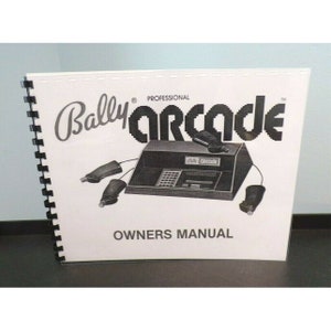 以下が含まれることがあります： ゲーム機とコントローラーの画像が掲載された白黒のバリーアーケードプロフェッショナルオーナーマニュアル。マニュアルは黒いコイルで綴じられています。