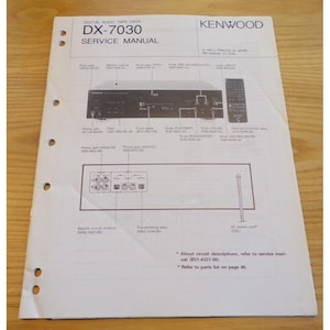 Puede incluir: Un manual de servicio en papel blanco para una pletina de casete de audio digital Kenwood DX-7030. El documento presenta diagramas técnicos del panel frontal, puertos de entrada y salida traseros y un mando a distancia con códigos.