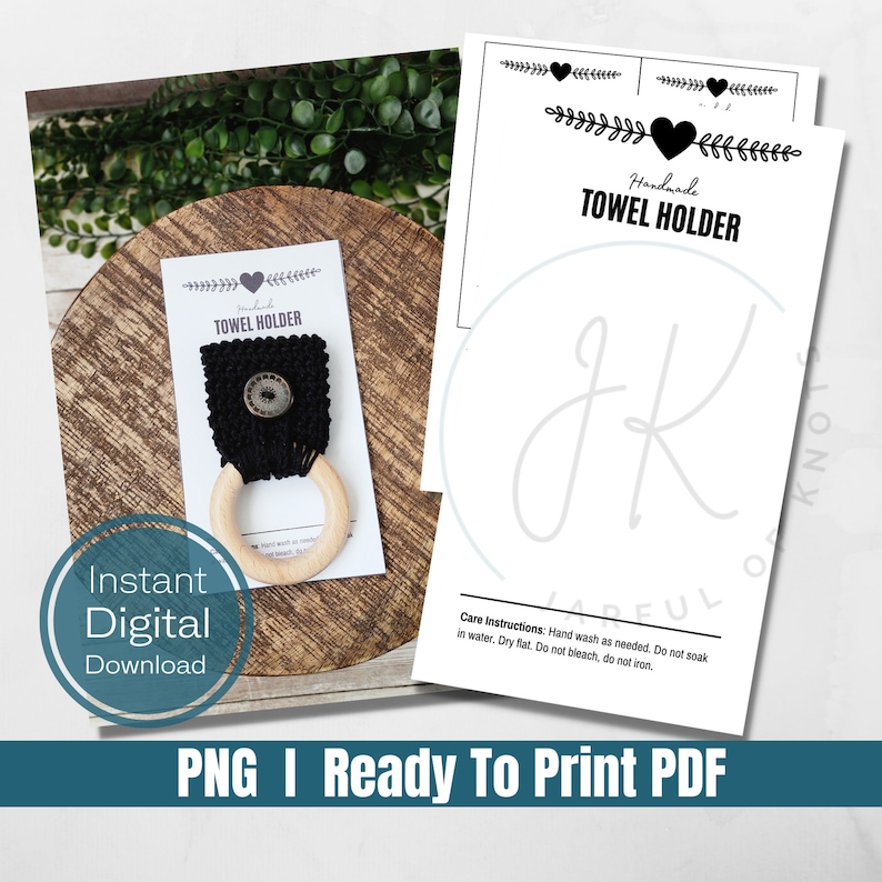 May include: Handmade black and white towel holder with a wooden ring and a black button. The holder is on a wooden surface. The text "Handmade Towel Holder" is on a white card with a black heart.