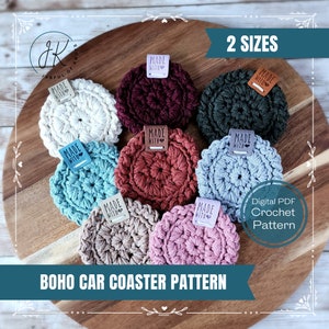 May include: A set of eight crocheted coasters in various colors, including white, maroon, green, blue, rust, beige, and pink. The coasters are arranged on a wooden surface and each has a small leather tag that says "Made with Love". The text "2 Sizes" and "Digital PDF Crochet Pattern" are displayed on the image. The text "BOHO CAR COASTER PATTERN" is displayed at the bottom of the image.