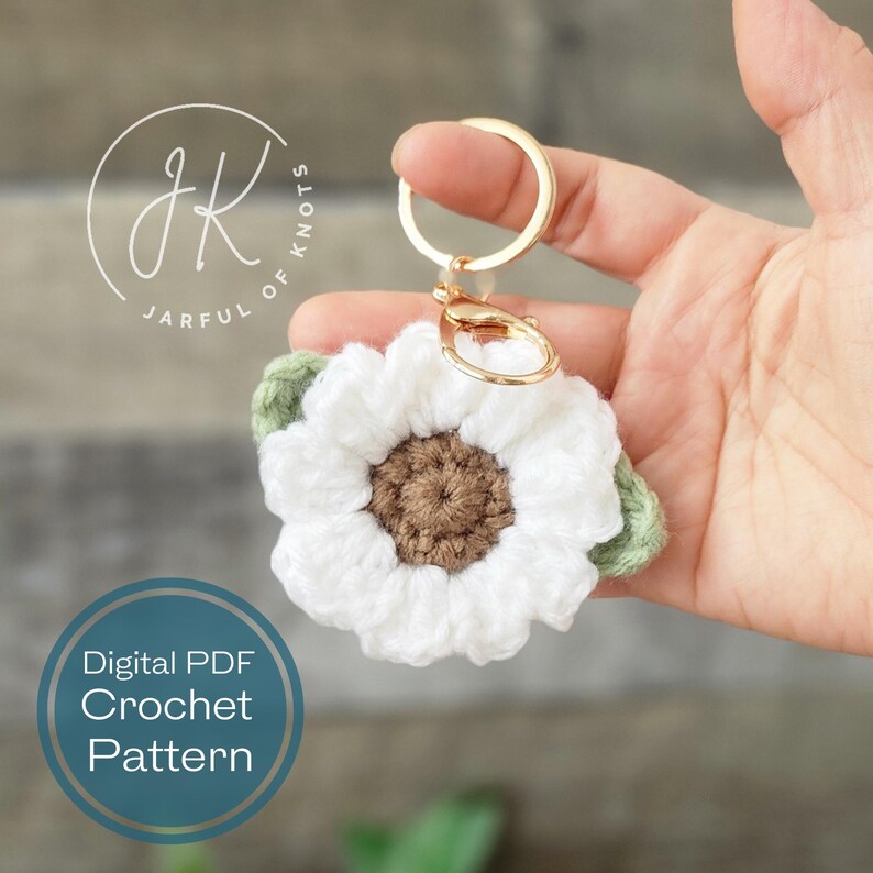 May include: White crocheted sunflower keychain with green leaves and a gold key ring. Digital PDF crochet pattern.