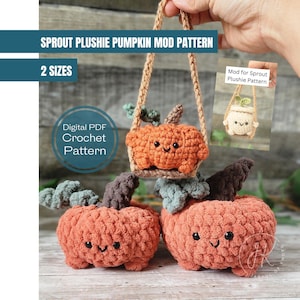 May include: A crochet pattern for a plush pumpkin in two sizes. The pattern is available as a digital PDF download. The image shows three pumpkins, one hanging from a swing, and two sitting on a wooden surface. The pumpkins are orange with brown stems and green leaves. The pattern includes instructions for making the pumpkins with a smiling face.
