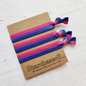 May include: Set of four blue, pink and purple striped hair ties. The hair ties are arranged on a brown card with the text "Starchasers.co.uk Handmade in Scotland with love."
