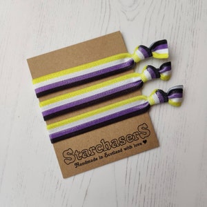 May include: Three yellow, white, purple and black striped hair ties on a brown card with the text "Starchasers Handmade in Scotland with love".