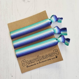 May include: Three blue, green and white striped hair ties on a brown card with the text "Starchasers Handmade in Scotland with love".