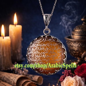 May include: A silver pendant necklace with a round, amber-colored stone inscribed with Arabic script. The pendant hangs from a delicate chain. The background includes lit candles, scrolls, and flowers. The Etsy shop name "ArabicSpells" is visible.