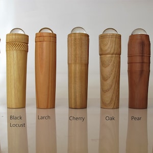 May include: Eight wooden kaleidoscopes with different wood types, including maple, black locust, larch, cherry, oak, pear, and fumed oak. Each kaleidoscope has a clear glass sphere at the top.