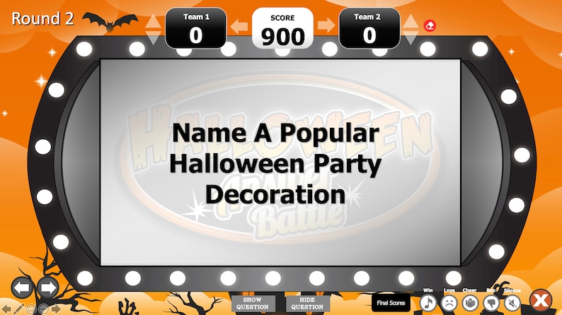 May include: A game show screen with a black frame and white lights around the edge. The screen displays the text "Name A Popular Halloween Party Decoration" in a white font on a gray background. The game show is called "Halloween Party Battle". The score is 900 for the team on the top of the screen.