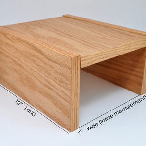 May include: A wooden shelf unit with a natural finish. The shelf is 10 inches long, 7 inches wide (inside measurement), and 5 inches high.