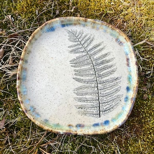 May include: A set of three ceramic mugs with a speckled, matte finish in cream, light grey, and dark grey. Each mug has a simple, minimalist design, ideal for coffee or tea.