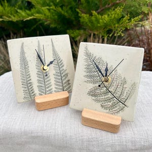 Pode incluir: Um conjunto de três canecas de cerâmica com acabamento fosco e salpicado. As canecas são em tons de creme, cinza claro e cinza escuro. Cada caneca tem um design simples e minimalista.