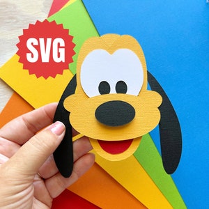 May include: SVG file for a paper craft of Pluto, a cartoon dog with yellow fur, black ears, a black nose, and white eyes. The craft is made with different coloured cardstock.