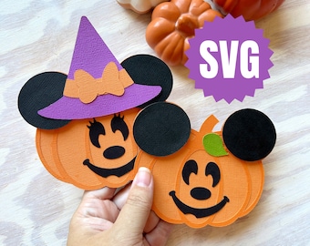May include: Two papercraft pumpkin Mickey Mouse characters. One is wearing a purple witch hat with an orange bow. The other has a green leaf on top. Both have black ears and black facial features. The text "SVG" is on a purple starburst.