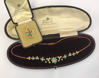 May include: An antique gold necklace and pendant set. The necklace features turquoise and pearl accents. The pendant is heart-shaped, with turquoise and pearl details. Both pieces are displayed in their original presentation boxes.
