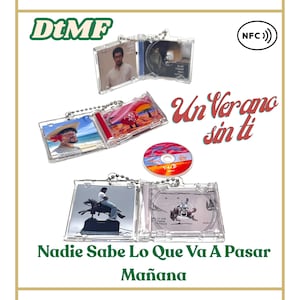 May include: Clear plastic CD keychains featuring album art and the text "Un Verano Sin Ti" and "Nadie Sabe Lo Que Va A Pasar Mañana". The keychains have silver ball chain attachments. A single CD with a colorful design is also visible.