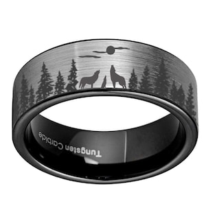 May include: A black tungsten carbide ring with a forest and wolf design. The ring features a brushed silver band with a silhouette of trees, wolves, and a moon. The words "Tungsten Carbide" are engraved on the inside of the ring.