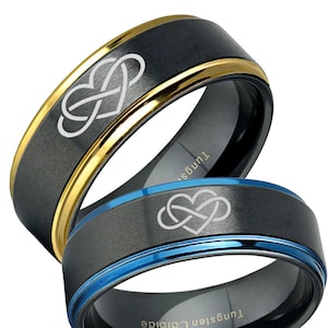 May include: Two black tungsten carbide rings with a heart-shaped infinity symbol design. One ring has a gold-colored edge, and the other has a blue edge. The rings are close together, showcasing the intricate details of the design.