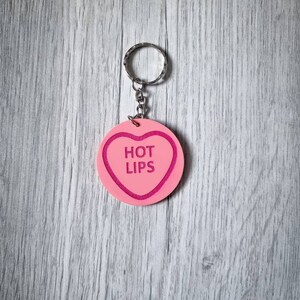 May include: Pink heart-shaped keychain with the words "HOT LIPS" in pink lettering.