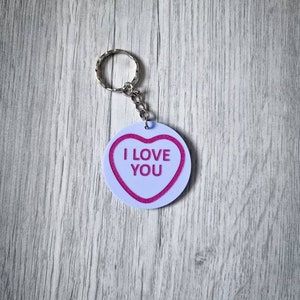 May include: White heart-shaped keychain with a pink "I LOVE YOU" message.