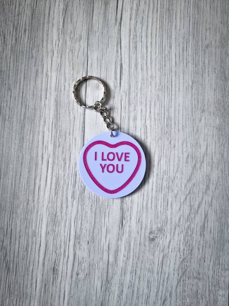 May include: White heart-shaped keychain with a pink "I LOVE YOU" message.