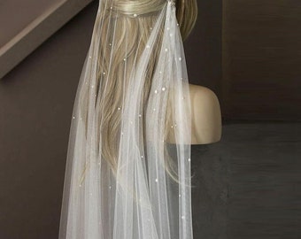May include: A white bridal veil with a delicate pearl design. The veil is made of soft tulle and is perfect for a wedding ceremony or reception.
