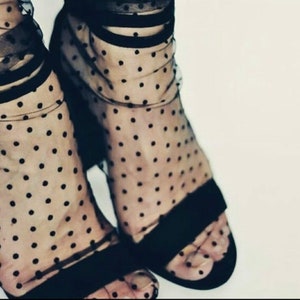 May include: Black sheer socks with polka dots and black heels.
