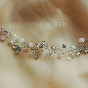 May include: A delicate silver wire hair vine with pink and blue beads and crystals. SAVCHENKO DESIGN is written in the background.