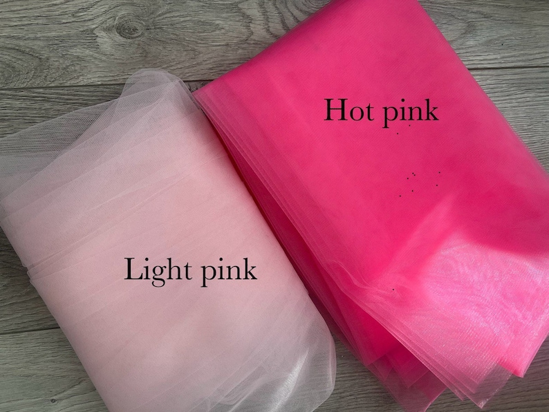 May include: Two pieces of tulle fabric, one light pink and one hot pink. The fabric is soft and sheer, and it is perfect for crafting or decorating.