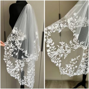 Peut inclure: Un voile de mariée blanc avec une broderie florale délicate. Le voile est en tulle doux et a un bord festonné.