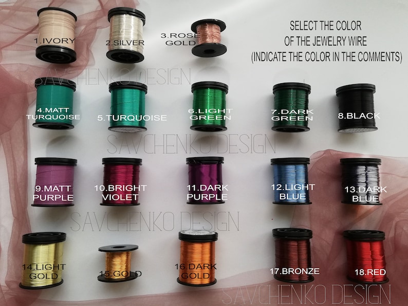 May include: Eighteen spools of jewelry wire in various colors, including ivory, silver, rose gold, turquoise, green, black, purple, violet, blue, bronze, and red. The spools are labeled with numbers 1 through 18. The text "SELECT THE COLOR OF THE JEWELRY WIRE (INDICATE THE COLOR IN THE COMMENTS)" is at the top of the image.