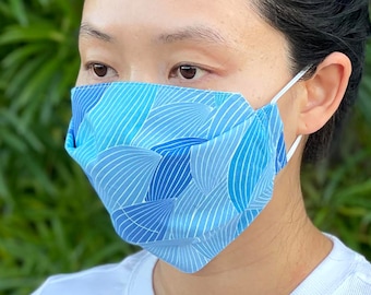 Puede incluir: Una persona usando una mascarilla facial con estampado azul y blanco con el texto "Blue Rolling Hills".