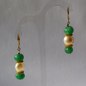 May include: A pair of gold earrings with green and white beads. The earrings have a simple design with three beads on each earring.