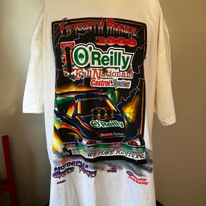 May include: White t-shirt with a graphic print of a drag racing car. The graphic features the text "2000 O'Reilly Fall Nationals Presented by Castrol Syntec" and "We Have Ignition".