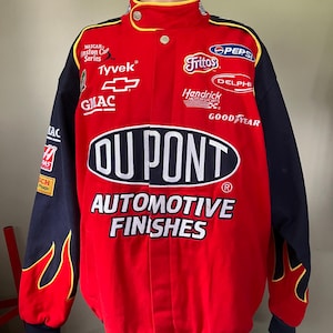 May include: A red and blue racing jacket with the DuPont Automotive Finishes logo, featuring flames on the sleeves and sponsors like Fritos, Pepsi, and GMAC.