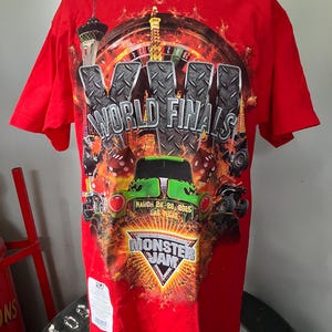 Puede incluir: Camiseta roja con un estampado gr&aacute;fico de un cami&oacute;n monstruo, una ruleta de casino y el texto "XVI World Finals" y "Monster Jam". El texto "March 26-28, 2015 Las Vegas" tambi&eacute;n est&aacute; impreso en la camiseta.