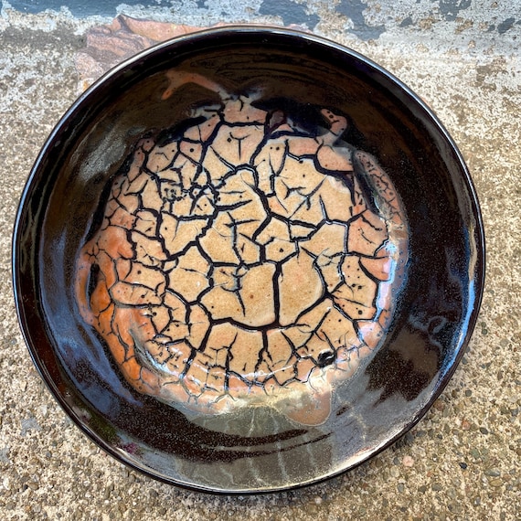 Hand-thrown porcelain bowl with a cracked-earth glaze that looks like an aerial photo of a drought — genuinely striking craft object.