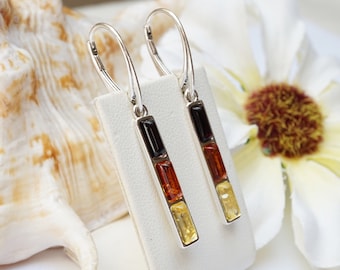 May include: Silver dangle earrings with three rectangular amber stones in black, orange, and yellow.