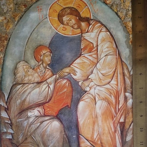 Puede incluir: Una pintura religiosa que representa a tres figuras. La figura central es un hombre con un halo, que lleva una túnica blanca y extiende su mano derecha. A su izquierda, una mujer con una túnica roja mira a la figura central. A su derecha, un hombre mayor con barba blanca y túnica blanca mira a la figura central. La pintura está realizada en un estilo tradicional con colores apagados.