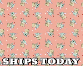 May include: Pink fabric with a repeating pattern of a green baby Yoda character with big ears. The fabric has a white heart pattern and the text "SHIPS TODAY" printed at the bottom.