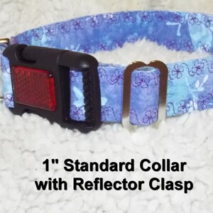 May include: A 1 inch wide blue and purple floral dog collar with a silver D-ring and a black buckle with a red reflector. The text "1" Standard Collar with Reflector Clasp" is printed below the collar.