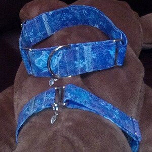 K&ouml;nnte beinhalten: Zwei blaue Hundehalsb&auml;nder mit einem Schmetterlingsmuster. Die Halsb&auml;nder sind aus Stoff und haben silberne Metallbeschl&auml;ge.